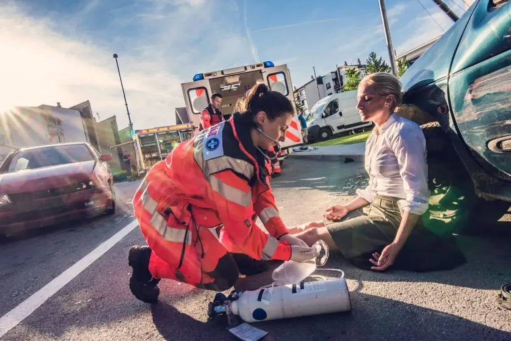 Rib and Chest Pain After an Airbag Deployment - Women with chest pain on ground with medic helping