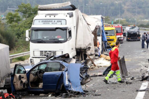 A truck crash leaves a car completely destroyed. Authorities are on the scene.