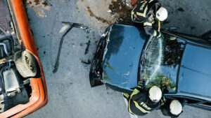 a fatal t bone car accident, seen from a senior point of view. No victim is seen but there are rescuers on the scene