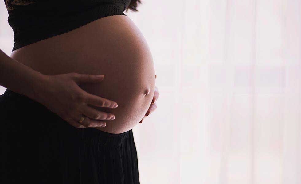 woman holds her stomach after the wrongful death of fetus in arizona