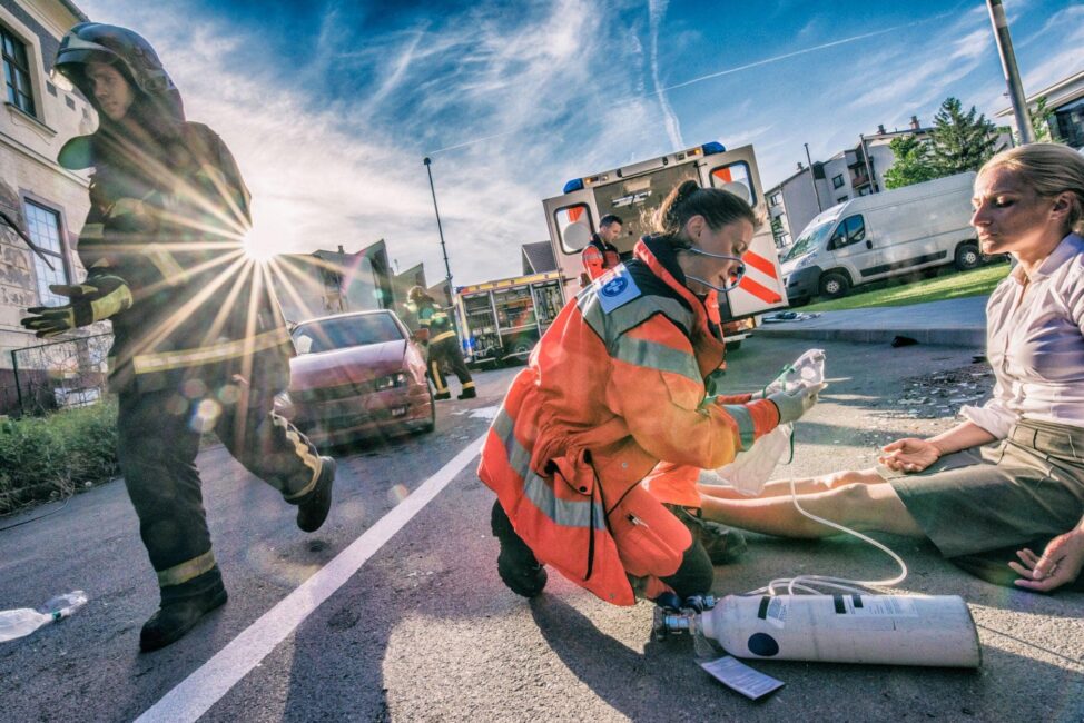 EMT rescuing a man in an car accident on the freeway