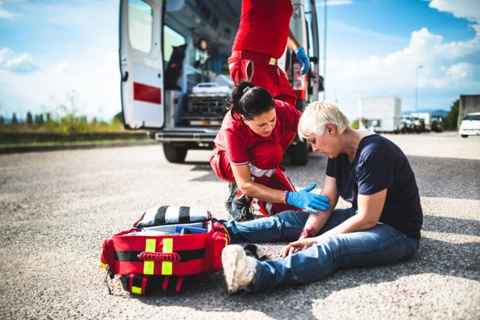 rescuers checking on a victim of a hit and run intersection accident