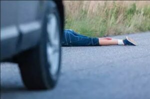 A car fleeing the scene of an accident, leaving the victim behind. The victim is on the flor with a bleeding leg.