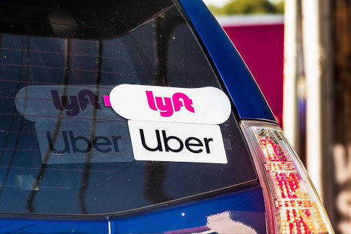 The back of a car is seen with an Uber/Lyft sticker