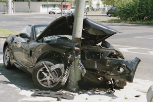 Car completely destroyed after colliding head-on with a pole, with significant damage to the front of the vehicle